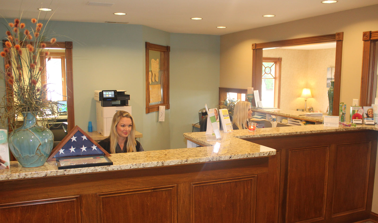 The image shows a modern dental clinic interior with various pieces of equipment, including a dental chair and an X-ray machine.